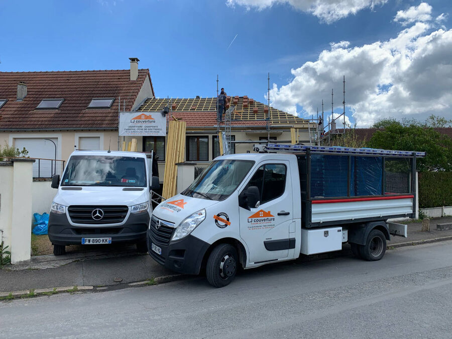 Véhicules LJ Couverture devant un chantier de toiture en cours dans les Yvelines