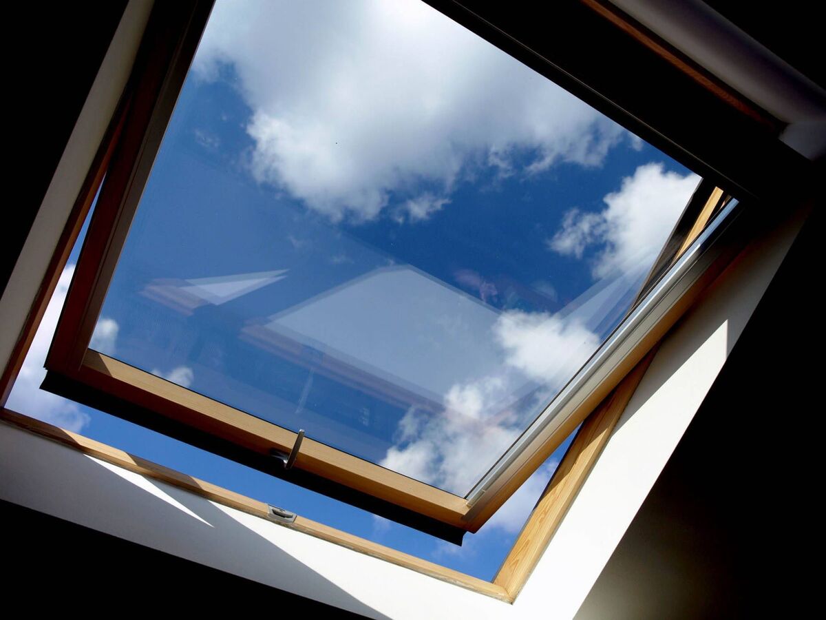 Gros plan sur une fenêtre de toit Velux neuve, battant ouvert sur le ciel
