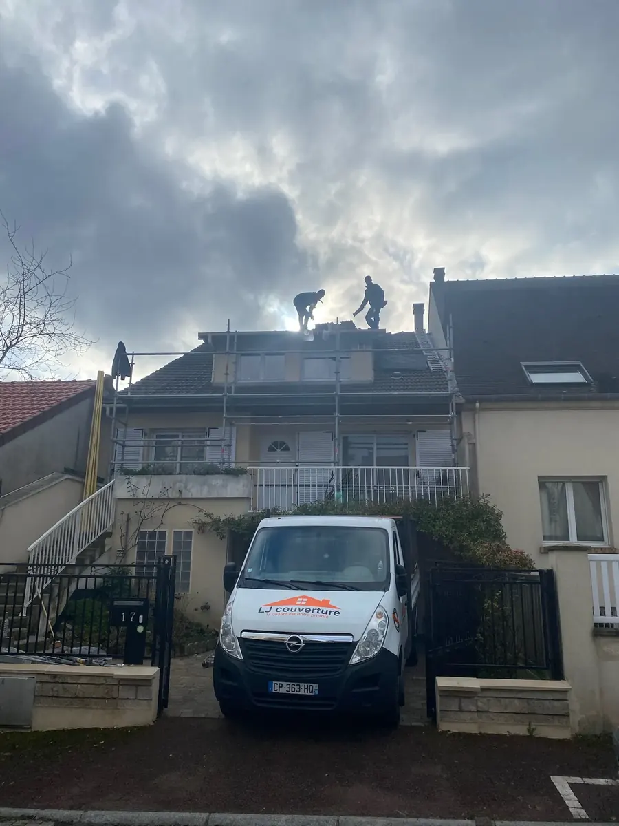 Couvreurs de LJ Couverture au travail sur la toiture d'une maison de Chevreuse, fourgon de l'entreprise devant l'entrée