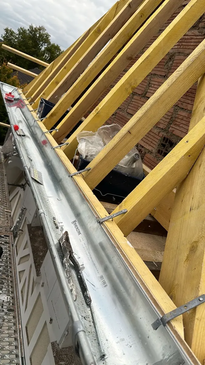 Gouttière en zinc neuve fixée sous les chevrons et les liteaux d'une toiture à Chevreuse