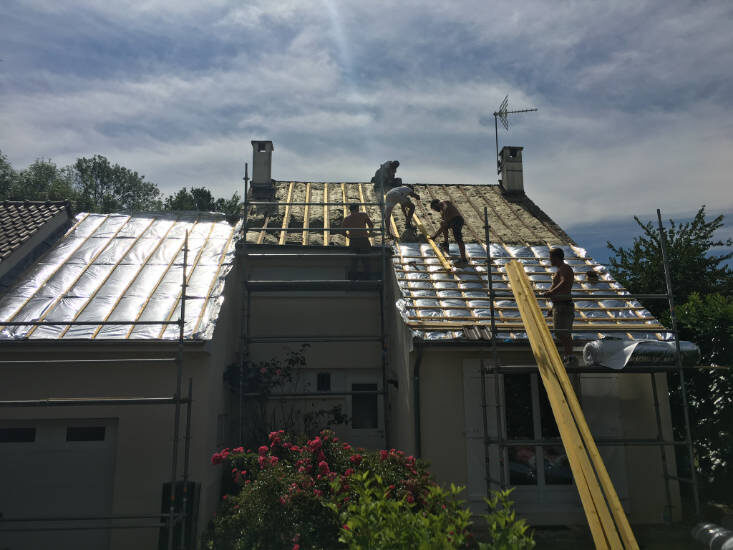 Équipe LJ Couverture posant un isolant réfléchissant sur la toiture d'un pavillon des Yvelines