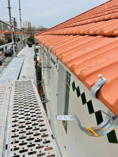 Pose de tuiles neuves sur une toiture depuis un échafaudage, chantier LJ Couverture