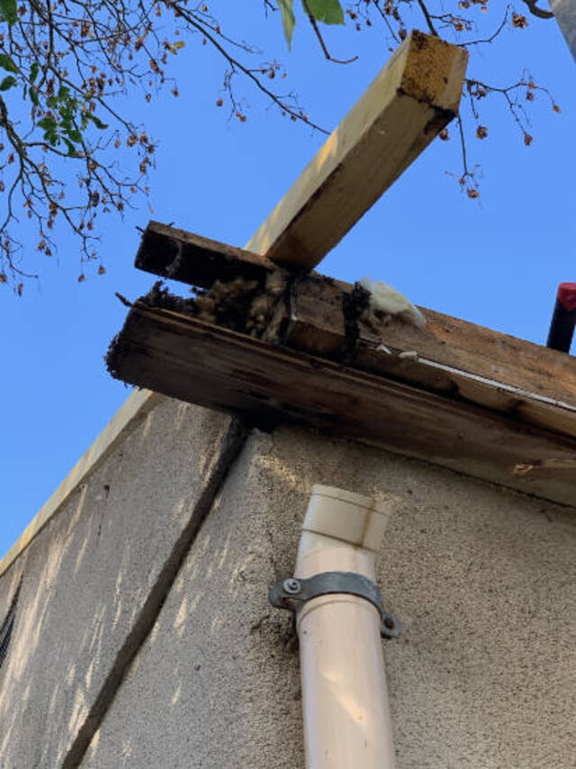 Réparation d'une gouttière en zinc en débord de toit à Bullion